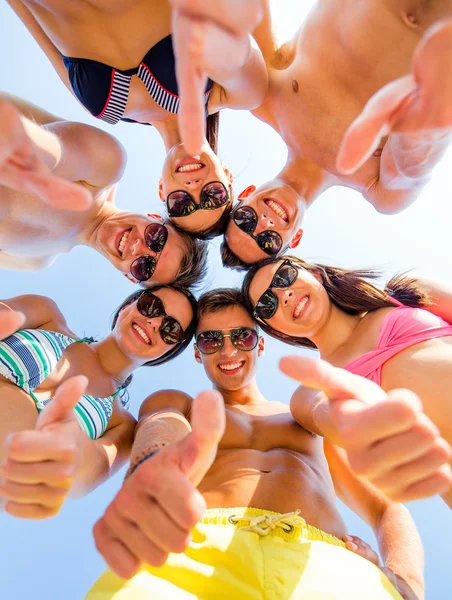 Amigos sonrientes mostrando pulgares hacia arriba en círculo —  Fotos de Stock