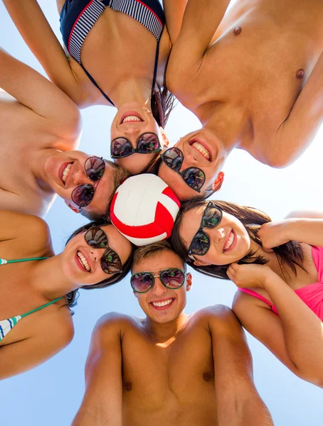 Улыбающиеся друзья в кругу на летнем пляже — стоковое фото