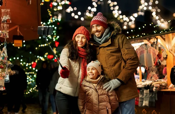 Familia feliz tomando selfie en el mercado de Navidad —  Fotos de Stock