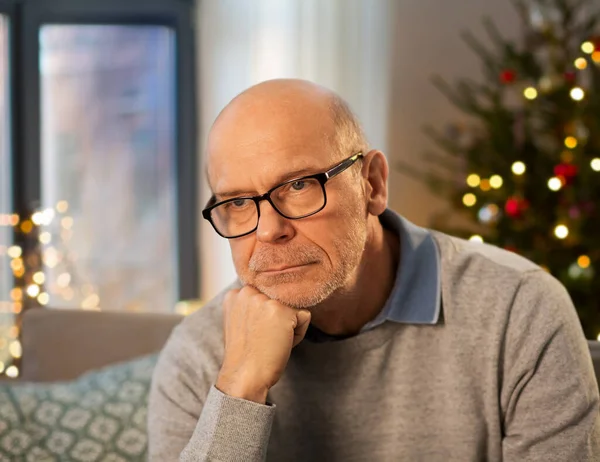 Triste hombre mayor en gafas en casa en Navidad — Foto de Stock