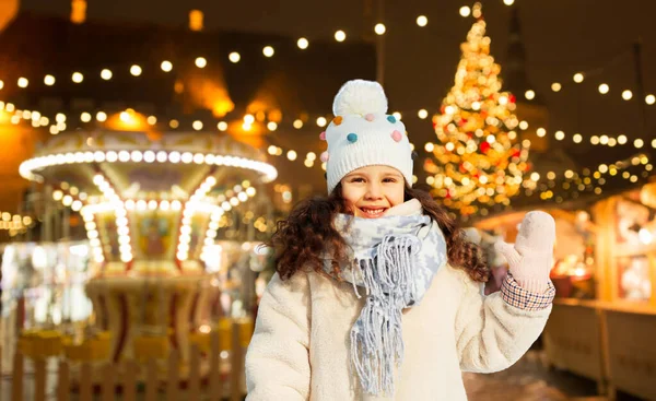 Heureuse petite fille agitant la main au marché de Noël — Photo