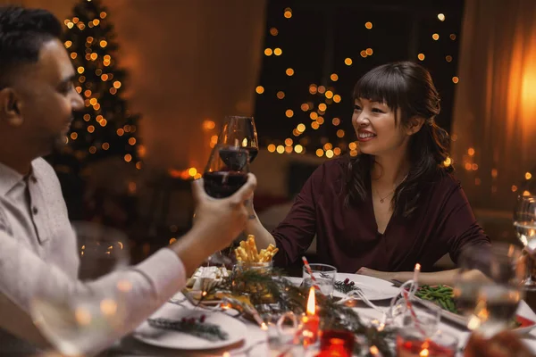 Amigos felices bebiendo vino en la fiesta de Navidad —  Fotos de Stock