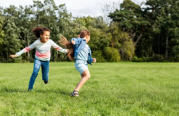 Meninas felizes jogando e correndo no parque — Fotografia de Stock