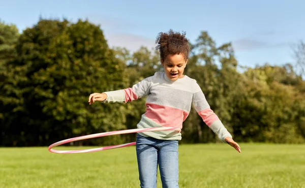 Szczęśliwa dziewczyna gra z hula hoop w parku — Zdjęcie stockowe