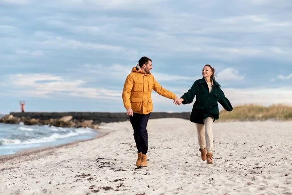 Пара бежит вдоль осеннего пляжа — стоковое фото