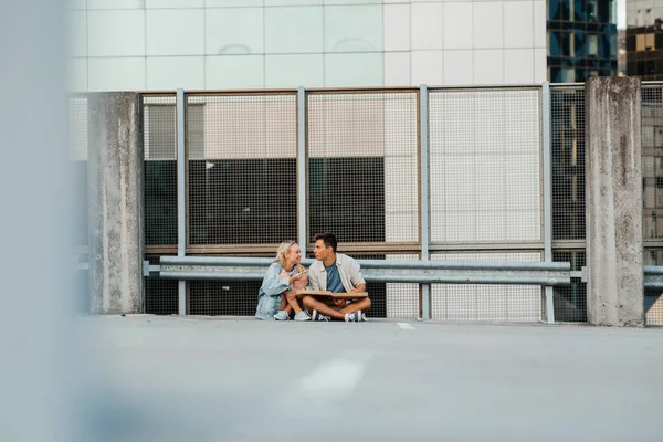 Щаслива пара їсть піцу на міському даху верхня парковка — стокове фото
