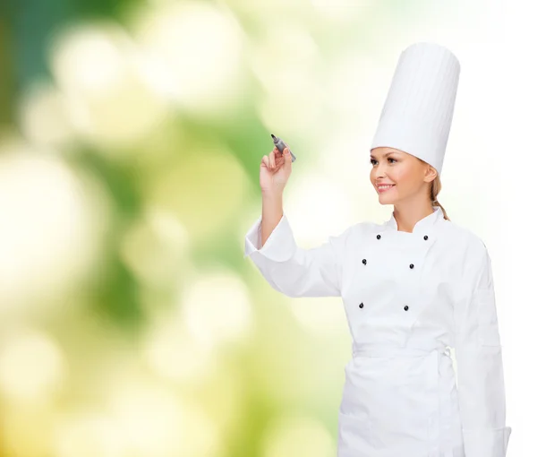 Glimlachend vrouwelijke chef-kok schrijven iets op lucht — Stockfoto