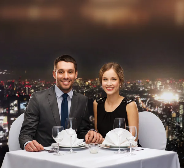 Smiling couple holding hands at restaurant — Stock Photo, Image