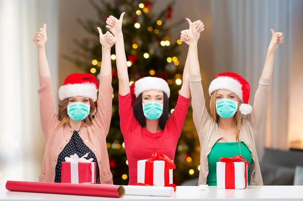 Women in masks packing christmas gifts at home — Stock Photo, Image