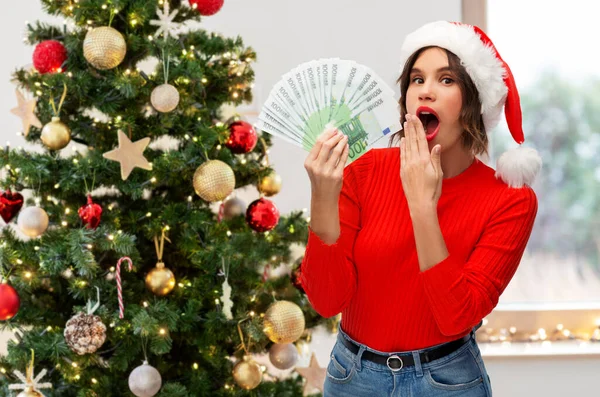 Överraskad kvinna i tomte hatt med pengar — Stockfoto