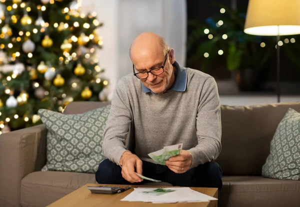 Senior comptant l'argent à la maison le jour de Noël — Photo