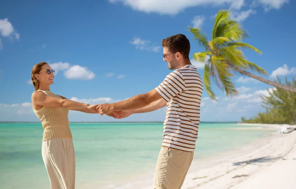 Szczęśliwa para trzymając się za ręce na tropikalnej plaży — Zdjęcie stockowe