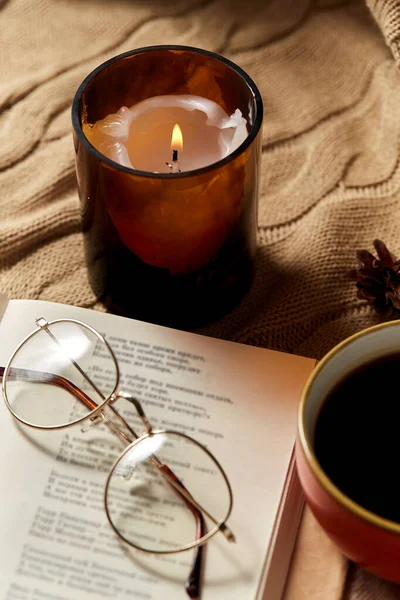 Libro, bicchieri, caffè e candela su coperta calda — Foto Stock