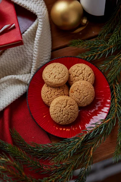 Galletas en el plato y rama de abeto de Navidad en casa — Foto de Stock