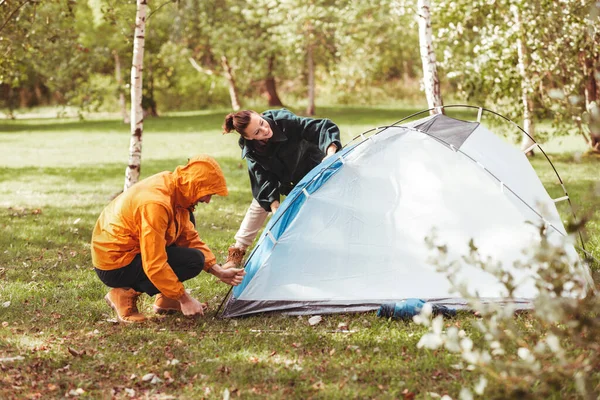 Couple heureux installant la tente à l'extérieur — Photo