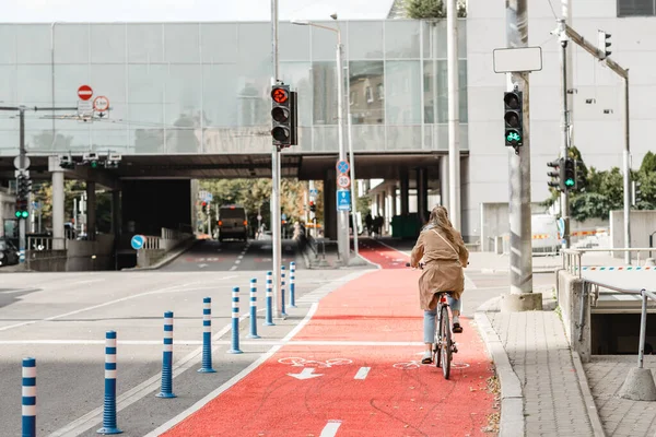 Kobieta jazda na rowerze wzdłuż czerwonej drogi rowerowej w mieście Obrazek Stockowy