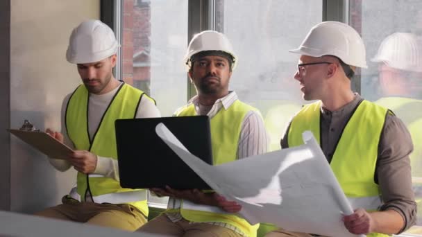 Arquitetos masculinos em capacetes com laptop no escritório — Vídeo de Stock