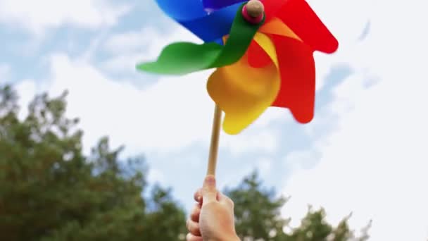 Hand houden kleurrijke pinwheel draaien op de wind — Stockvideo