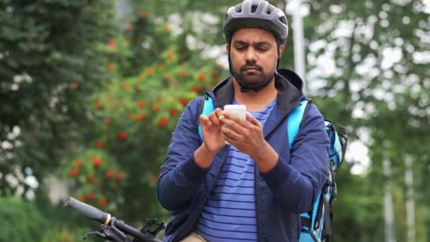 Homem de entrega com saco e bicicleta chamando no telefone — Vídeo de Stock