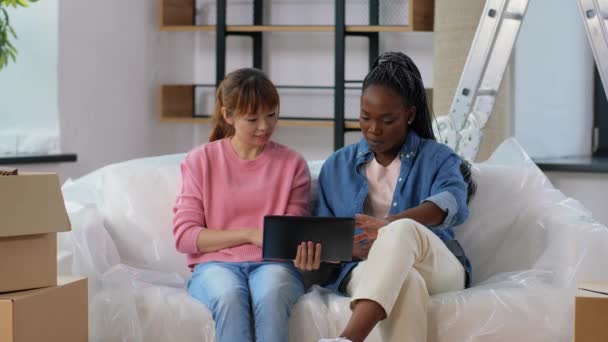 Vrouwen met tablet pc verhuizen naar nieuw huis — Stockvideo