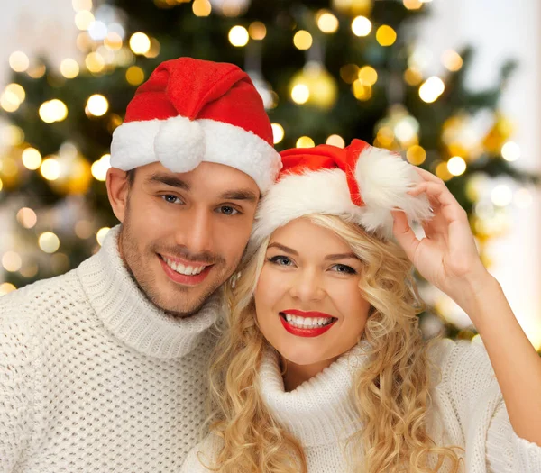 Feliz pareja en santas sombreros en Navidad — Foto de Stock