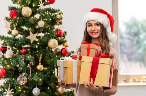 Ragazza adolescente in cappello di Babbo Natale con regalo di Natale — Foto Stock