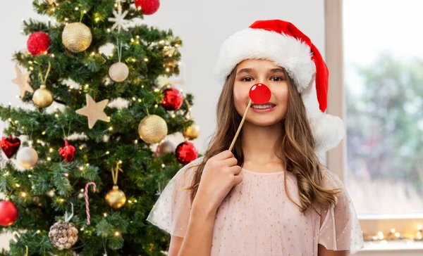 Happy teenage girl in santa hat on christmas — Stock Photo, Image