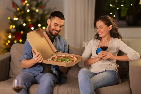 Lyckliga par äta take away pizza på jul — Stockfoto