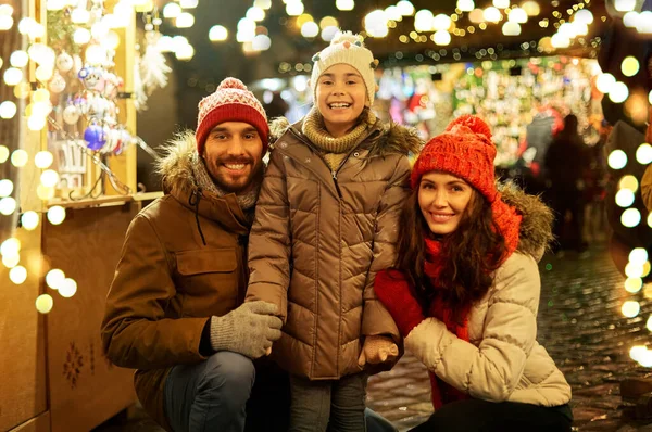 Gelukkig gezin op kerstmarkt in de stad — Stockfoto