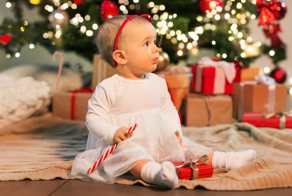 Baby girl at christmas tree with gifts at home — Stock Photo, Image
