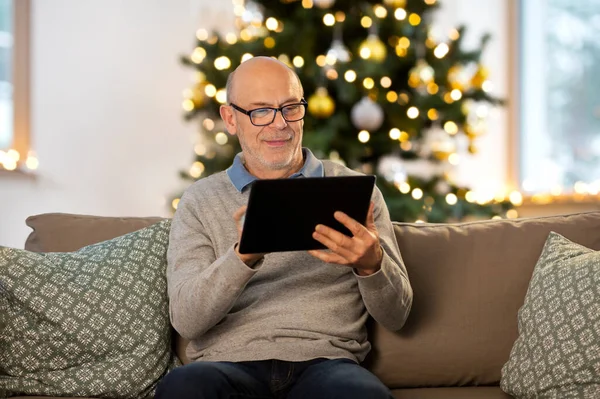 Uomo anziano con tablet pc a casa a Natale — Foto Stock