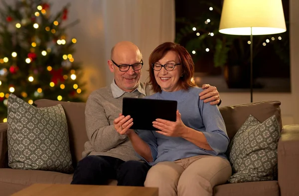 Senior paar met tablet pc thuis op kerst — Stockfoto