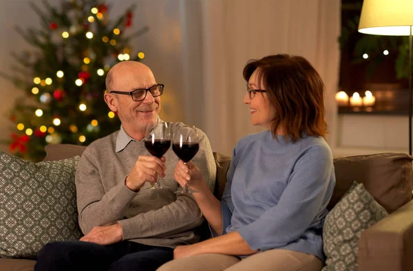 Glückliches Seniorenpaar trinkt an Weihnachten Rotwein — Stockfoto