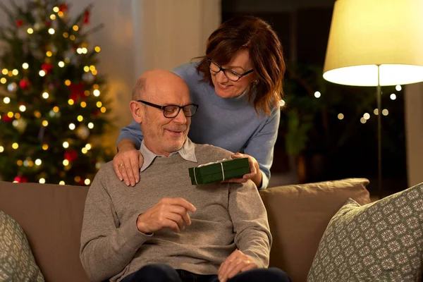 Gelukkig senior paar met kerstcadeau thuis — Stockfoto