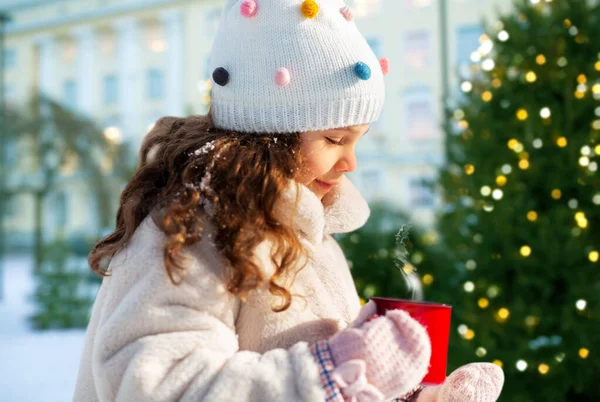 Klein meisje met kopje hete thee op kerstmis — Stockfoto
