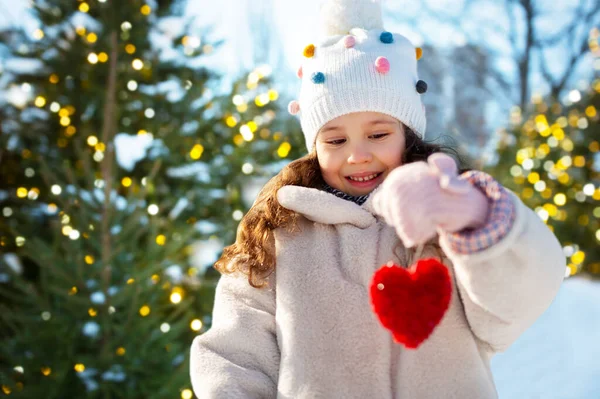 Gelukkig klein meisje met hart kerst decoratie — Stockfoto