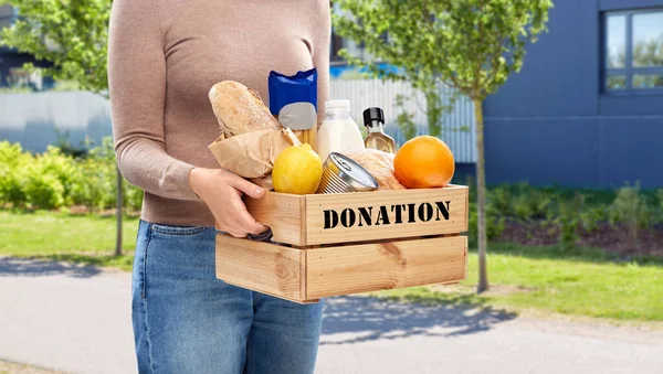 Mujer con donación de alimentos en caja de madera en la calle — Foto de Stock