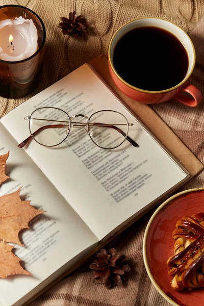 Kniha, skořicová buchta, káva a svíčka na podzim — Stock fotografie