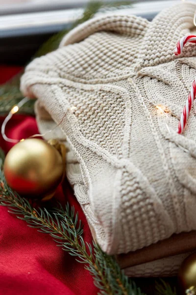 Close up of sweater, candy cane, christmas garland — Stock Photo, Image