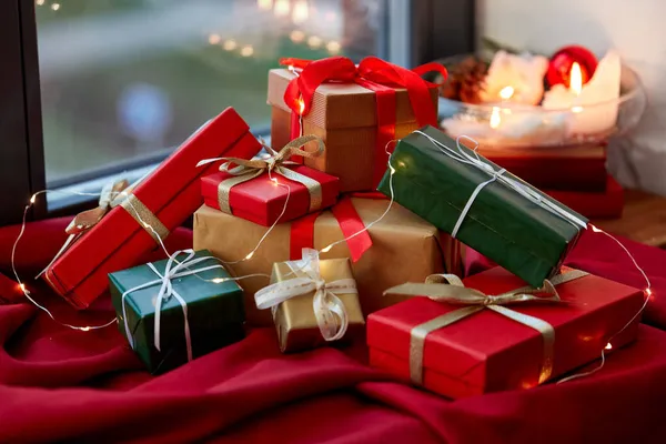 Regalos de Navidad en mantel rojo en alféizar de la ventana —  Fotos de Stock