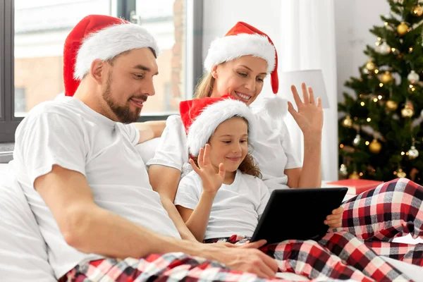 Familia feliz teniendo videollamada en Navidad en la cama — Foto de Stock