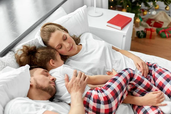 Щаслива сім'я спить в ліжку на Різдвяний ранок — стокове фото