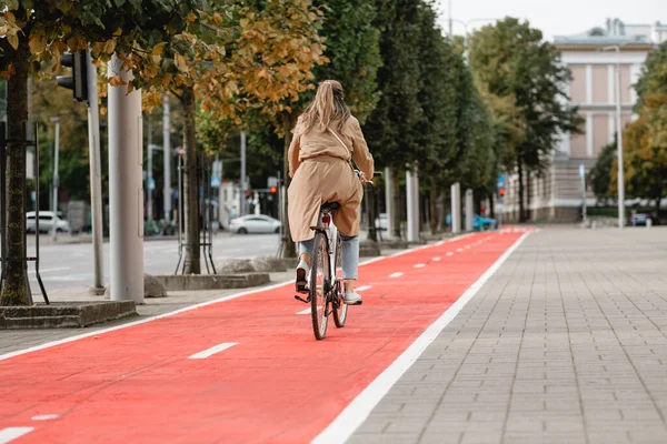 Γυναίκα ποδήλατο ιππασίας κατά μήκος της κόκκινης λωρίδας ποδήλατο στην πόλη — Φωτογραφία Αρχείου
