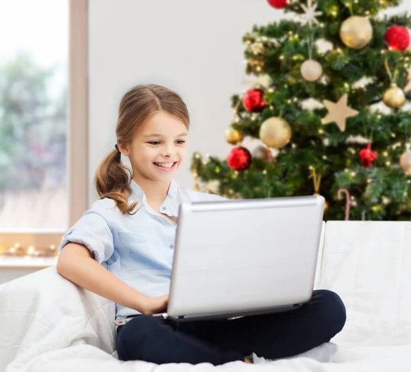 Menina com computador portátil em casa no Natal — Fotografia de Stock