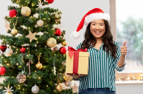 幸せな女性とクリスマスプレゼントが親指を立てて — ストック写真