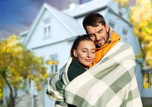 Щаслива пара в теплій ковдрі над будинком восени — стокове фото