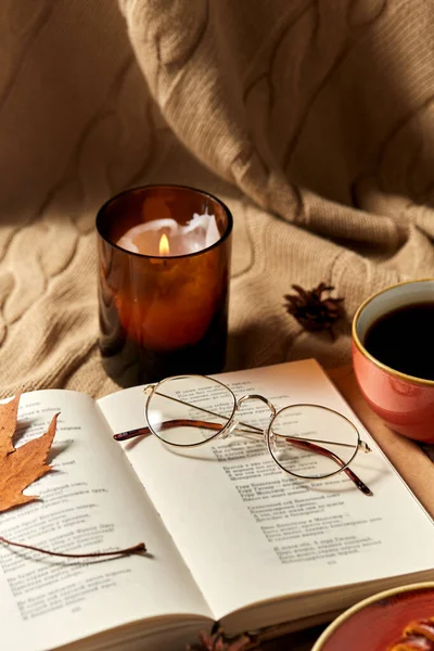 Kniha, brýle, káva a svíčka na podzim — Stock fotografie