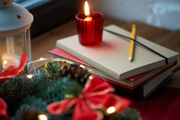 Grinalda de Natal, livros, vela, lanterna na janela — Fotografia de Stock