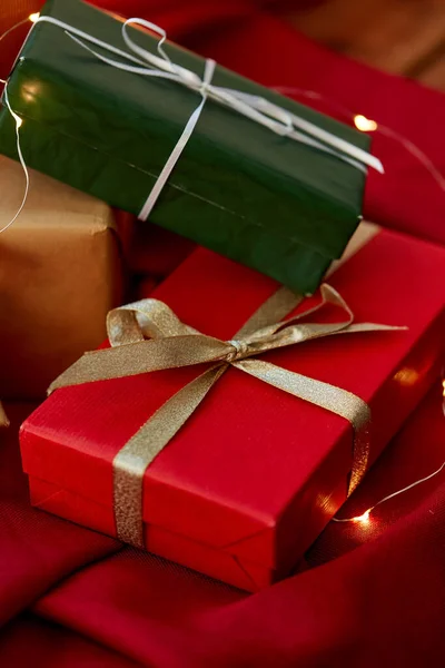 Kırmızı masa örtüsünde çelenk olan Noel hediyeleri. — Stok fotoğraf