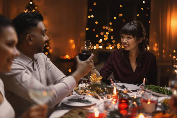 Boldog barátok bort isznak a karácsonyi partin — Stock Fotó
